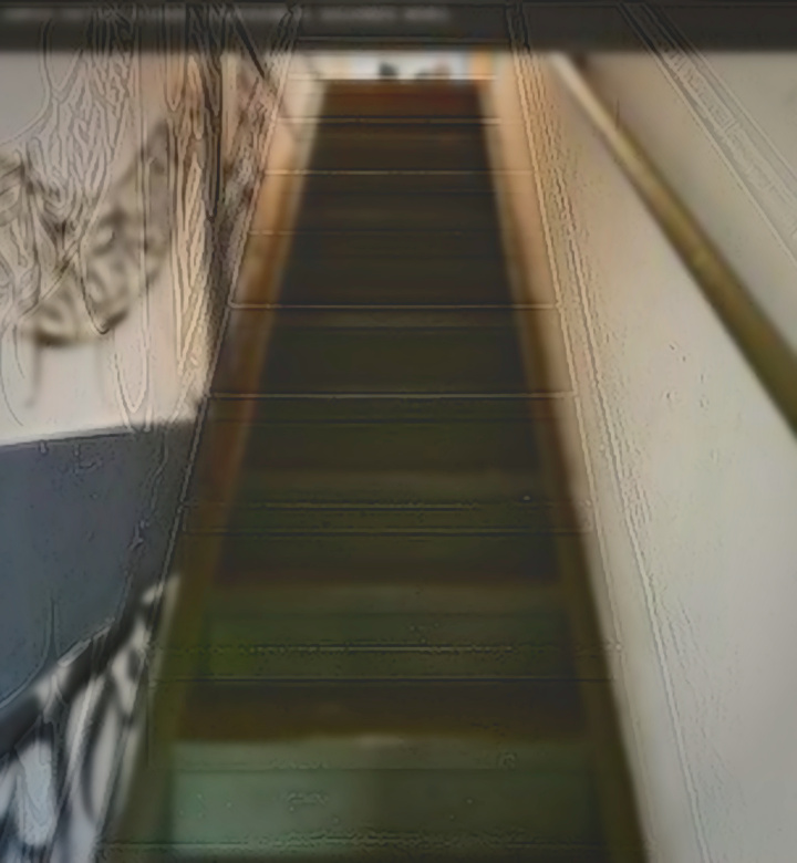 EST-08 · Escalera y Mural — Escalera interior en verde salvia acompañada por un mural caligráfico hacia el segundo nivel.